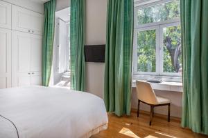 a bedroom with a bed and a desk and a window at Santiago de Alfama - Boutique Hotel in Lisbon