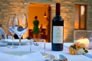 una bottiglia di vino seduta su un tavolo con bicchieri di VILLA PERMET a Përmet