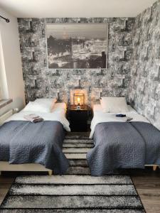 2 bedden in een slaapkamer met een bakstenen muur bij M Apartments Vuorentaustantie in Tampere