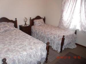 トレイラにあるApartamento Praia da Torreiraのベッドルーム1室(ベッド2台、窓付)