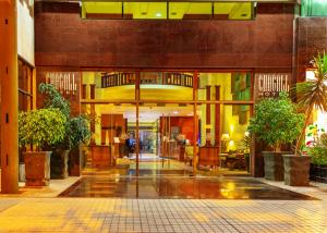 a lobby of a building with a hallway with plants at Hotel Chagall in Copiapó