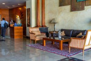 a living room with a couch and chairs and a table at Hotel Chagall in Copiapó