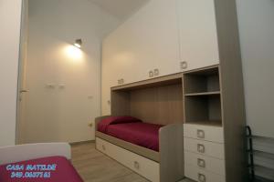 a small bedroom with a bed with a red blanket at Casa Matilde in Calasetta