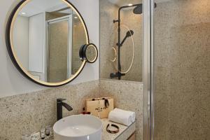 La salle de bains est pourvue d'un lavabo et d'un miroir. dans l'établissement PEPPER & PAPER Apartments, à Paris