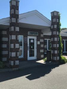 een bakstenen gebouw met een bord dat het hoofdkantoor leest bij Hôtel Marineau Shawinigan in Shawinigan