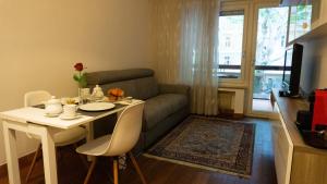 salon ze stołem i kanapą w obiekcie Meran/o Centro Guest House w Meranie