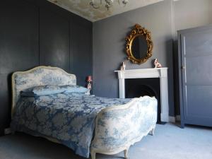 a bedroom with a bed with a mirror and a fireplace at The Bear Bread Bakery B&B, Ensuite rooms above the Bakery, Colyton in Colyton