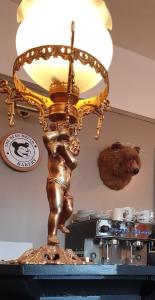 uma lâmpada de ouro com uma mulher em cima de uma mesa em The Bear Bread Bakery, boutique en-suite rooms with breakfast in the Bakery, in the heart of Colyton em Colyton