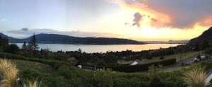 a view of a lake with a sunset in the background at Le Clos Du Lac - location de chambres in Veyrier-du-Lac