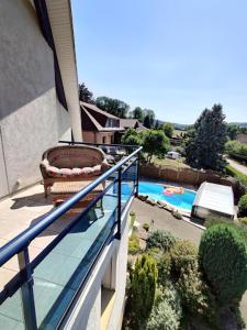 een balkon met een stoel en een zwembad bij La mouche,chambres avec terrasse vue sur la rivière in Humes