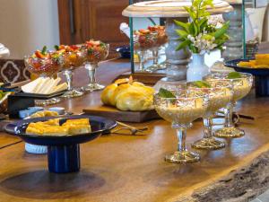 Hotel Estilo de Minas في ديامانتينا: طاولة مليئة بأطباق الطعام وكؤوس النبيذ