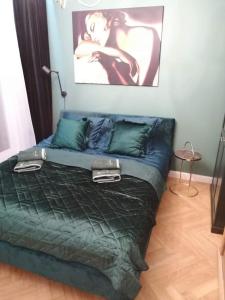 a bed with a green comforter in a room at Luksusowy Apartament nad morzem in Gdańsk