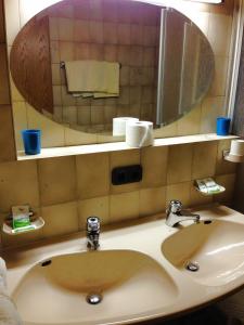 a bathroom sink with a large mirror above it at Beim Haxenwirt in Immenstadt im Allgäu