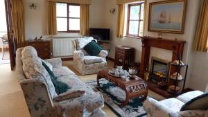 ein Wohnzimmer mit 2 Sofas und einem Kamin in der Unterkunft Willow Cottage in North Lydbury