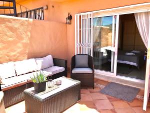 a living room with a couch and a chair at Marbella Deluxe Rooms in Royal Cabopino Townhouse in Marbella