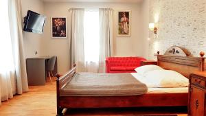 a bedroom with a bed and a red chair at Euro Aparthotel in Tarnów