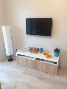 a living room with a flat screen tv on a wall at Słoneczne Tarasy by Marta in Dziwnówek +5 photos