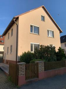 a house with a wooden fence in front of it at Ferienwohnung Fridolin in Bad Staffelstein