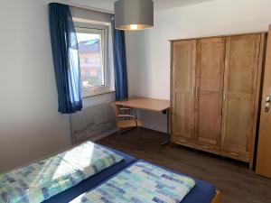 een slaapkamer met 2 bedden, een bureau en een raam bij Ferienwohnung Fridolin in Bad Staffelstein