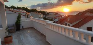 un balcón de una casa con una puesta de sol en el fondo en Apartments Bubalo, en Hvar