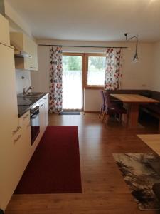 eine Küche und ein Esszimmer mit einem Tisch und einem Tisch in der Unterkunft s`Haus am Inn in Pfunds