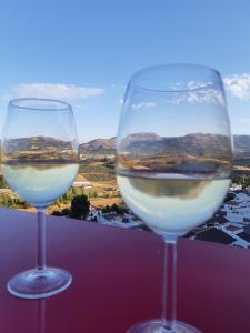 dos vasos de vino blanco sentados en una cornisa en Ronda apartamento San Jorge en Ronda