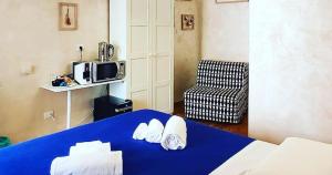 Habitación con cama azul y microondas. en Deluxe rooms and Chilling Jacuzzi Suite Guesthouse, en Roma