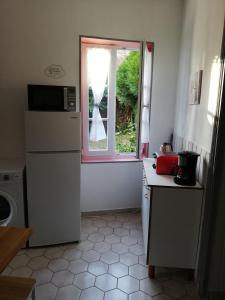 a kitchen with a refrigerator and a window at Sweet garden in La Fère