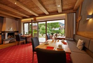 uma sala de jantar com uma mesa de madeira e cadeiras em Hotel Garni Zugspitz em Farchant