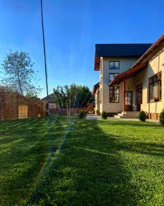 a large yard with a house and a building at Famíves vendégház in Racu