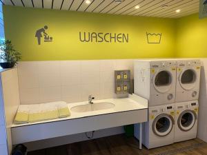 - un lave-linge et un lavabo dans la buanderie dans l'établissement Rhein-Camping Waldshut, à Waldshut-Tiengen