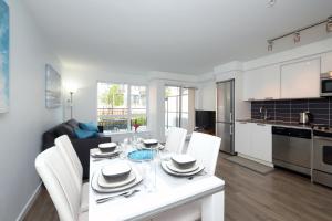 a kitchen and living room with a white table and chairs at Gorgeous Old Town Condo with Patio and Parking! in Victoria