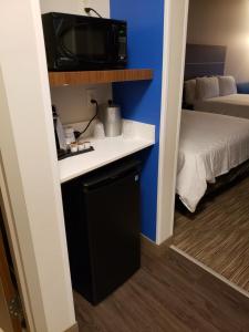 Habitación pequeña con TV y cama en Holiday Inn Express & Suites - Savannah N - Port Wentworth, an IHG Hotel en Port Wentworth