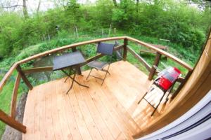 a wooden deck with two chairs and a table at Domek za Potokiem in Uherce Mineralne (7)