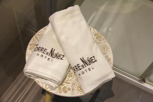 um par de toalhas num prato na casa de banho em Hotel Torre de Núñez em Lugo