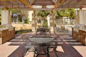 a patio with a table and chairs under a pergola at Hyatt House Dallas Las Colinas in Irving