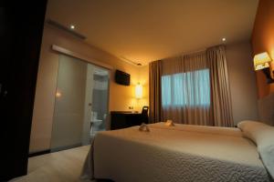 a hotel room with a bed and a bathroom at Hotel Torre de Núñez in Lugo