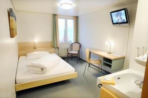 a hotel room with a bed and a television at Hotel Kreuz in Malters