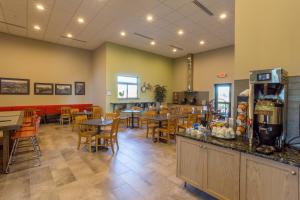 a restaurant with tables and chairs and a cafeteria at Timberlake Hotel in Staples