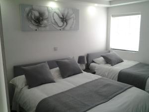 a bedroom with two beds and a window at Lady Charlotte Guest rooms triple rooms in Dowlais