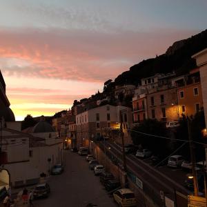 a city street at sunset with cars parked at Montecool in Baunei