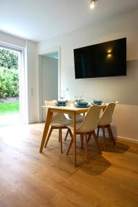 a dining room with a table with chairs and a tv at Strandglück in Scharbeutz