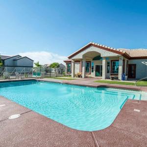 uma piscina em frente a uma casa em 213- 2BR Apartment in Coolidge, AZ w heated pool, gym em Coolidge