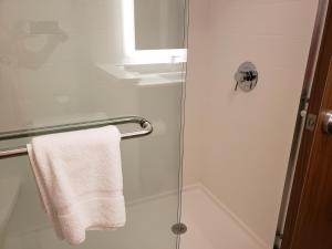 uma casa de banho com um chuveiro e uma toalha branca em Holiday Inn Express & Suites - Savannah N - Port Wentworth, an IHG Hotel em Port Wentworth