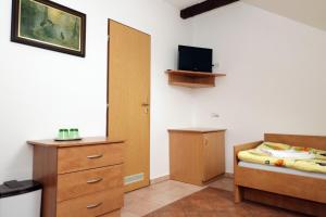 Habitación con dormitorio con cama y vestidor. en PENZION HŮRKA, en Dolní Libchavy