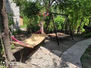 a swing set in a yard next to a tree at Narek B&B in Goris