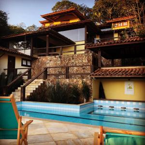 a house with a swimming pool in front of a building at Pousada Encanto de Búzios in Búzios