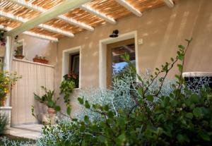 ein Haus mit einer Pergola und Pflanzen davor in der Unterkunft Acquamaris Tuerredda in Campionna