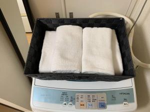 uma cesta de toalhas em cima de uma máquina de lavar roupa em Saint Million Tenjin - Vacation STAY 93047 em Fukuoka