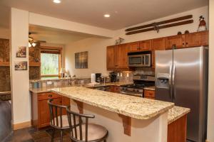 a kitchen with a stainless steel refrigerator and wooden cabinets at 6506 Settlers Creek Condo in Keystone